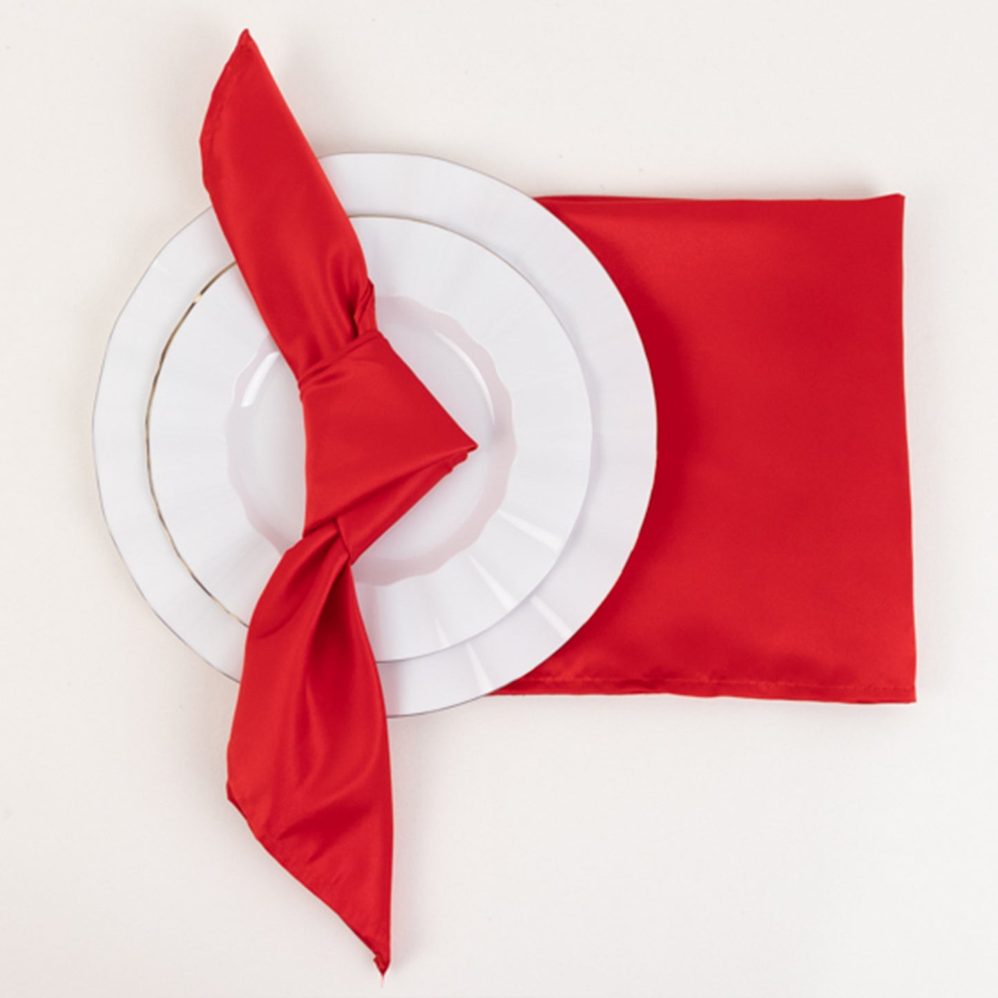 Red satin napkins with a stylish knot, perfect for elegant table settings.