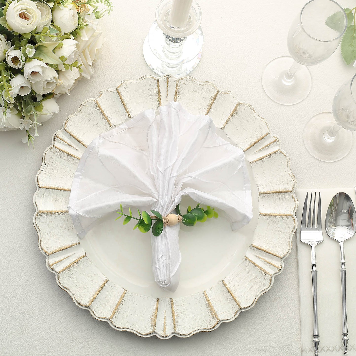Rustic green eucalyptus leaf wooden beaded jute napkin rings on a white plate.