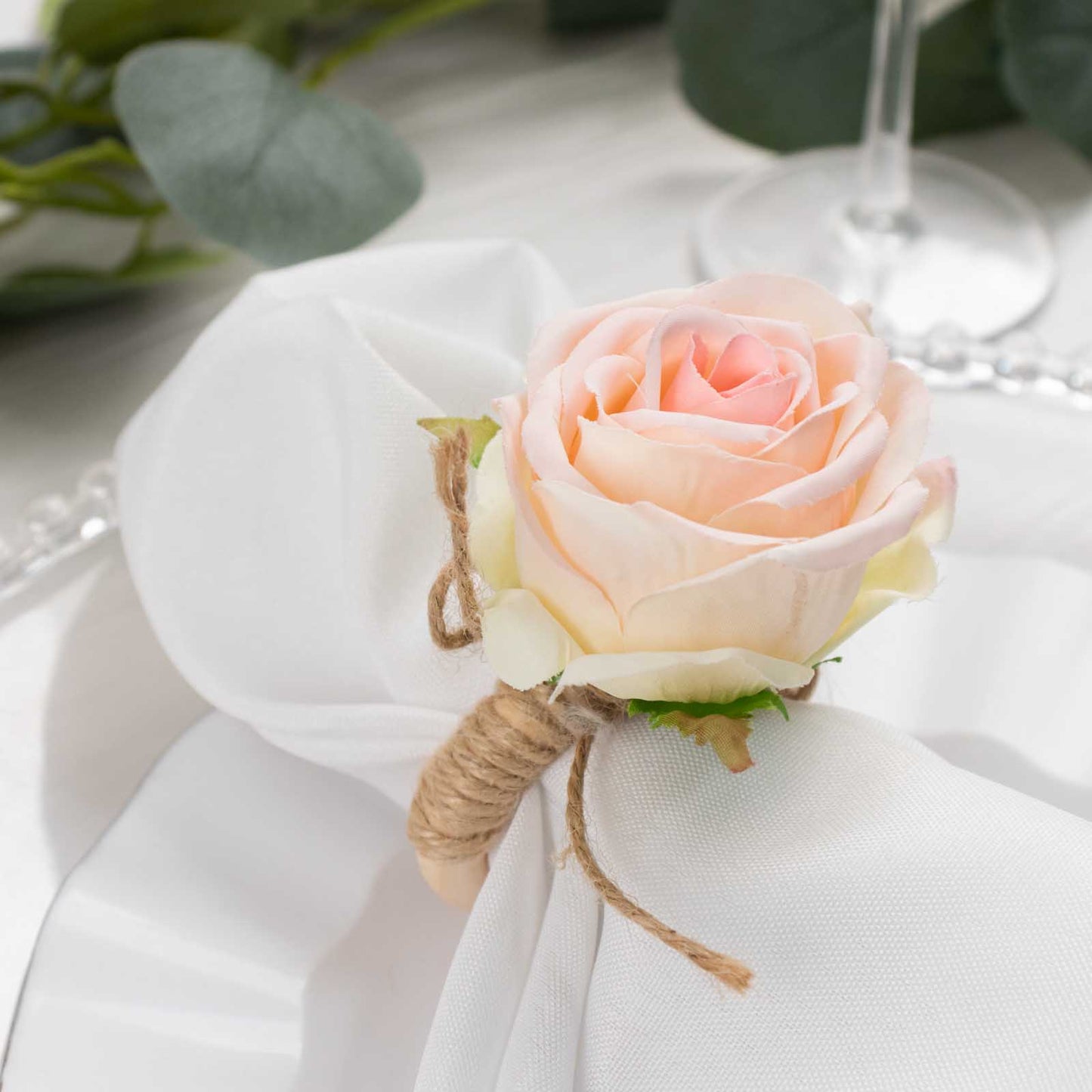 Blush artificial rose napkin holder with wooden ring, farmhouse style.