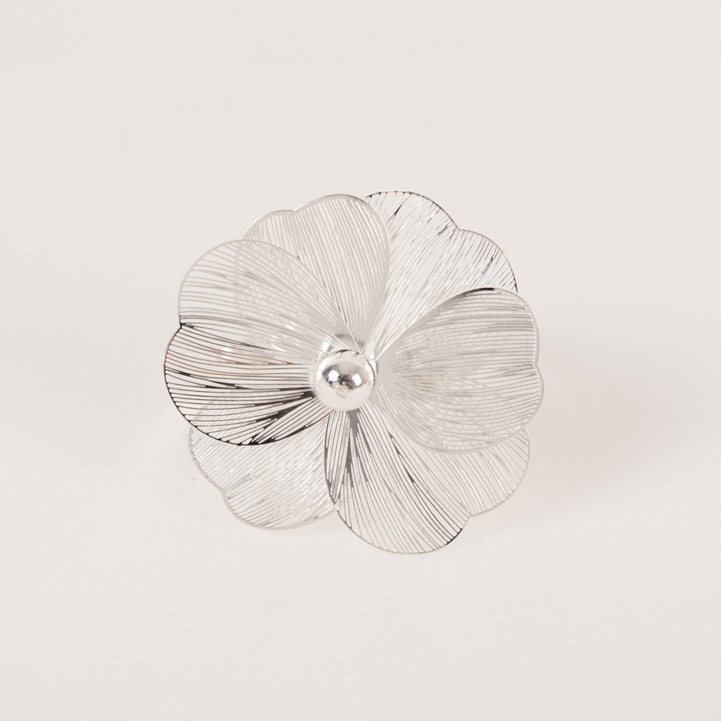 Silver metal jasmine flower napkin holder with pearl center.