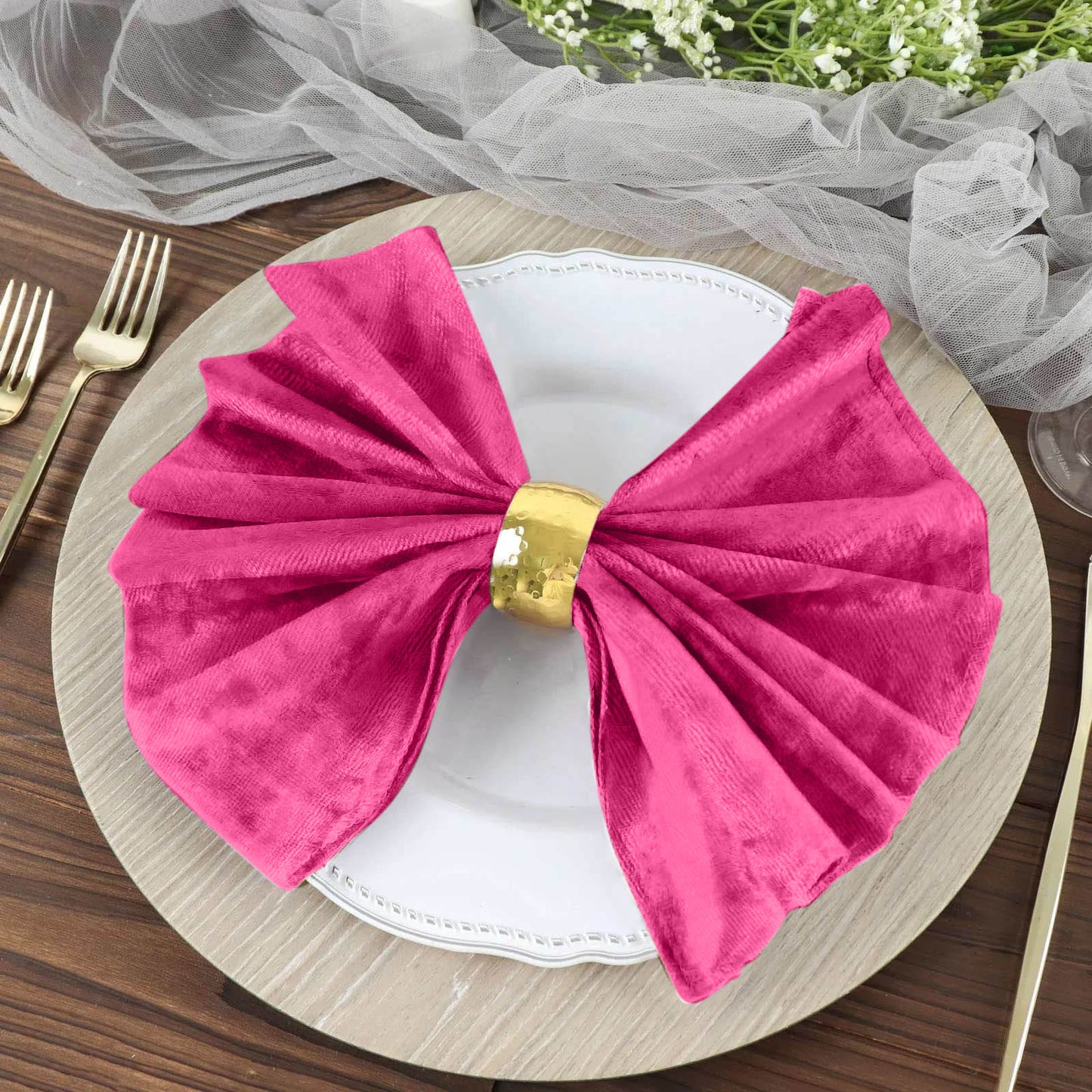Fuchsia premium crushed velvet linen napkin on a plate setting.