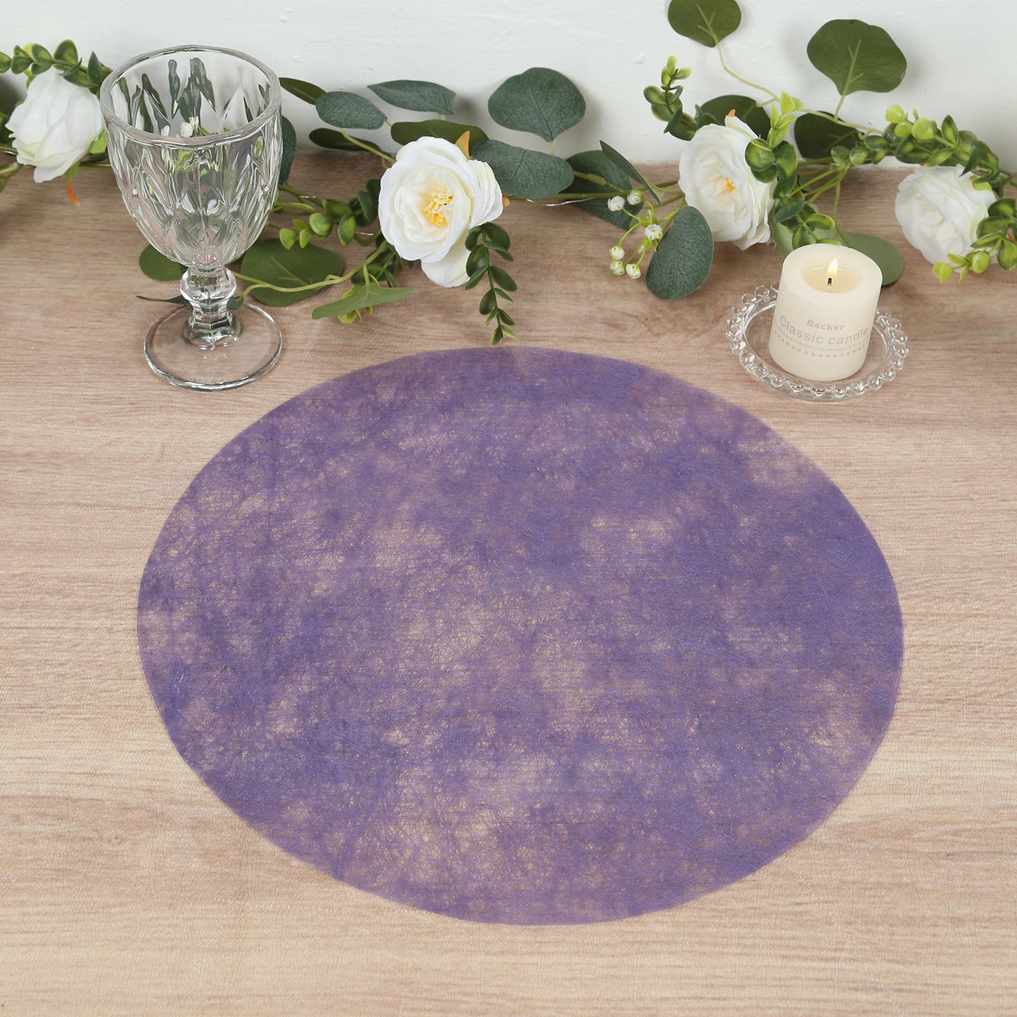 Lavender lilac round placemat on a wooden table with decor.