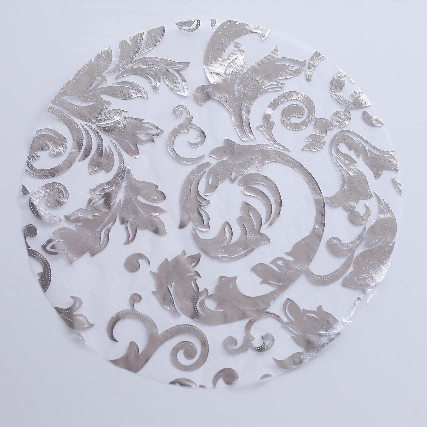 Metallic silver round placemat with floral swirl design on sheer organza.