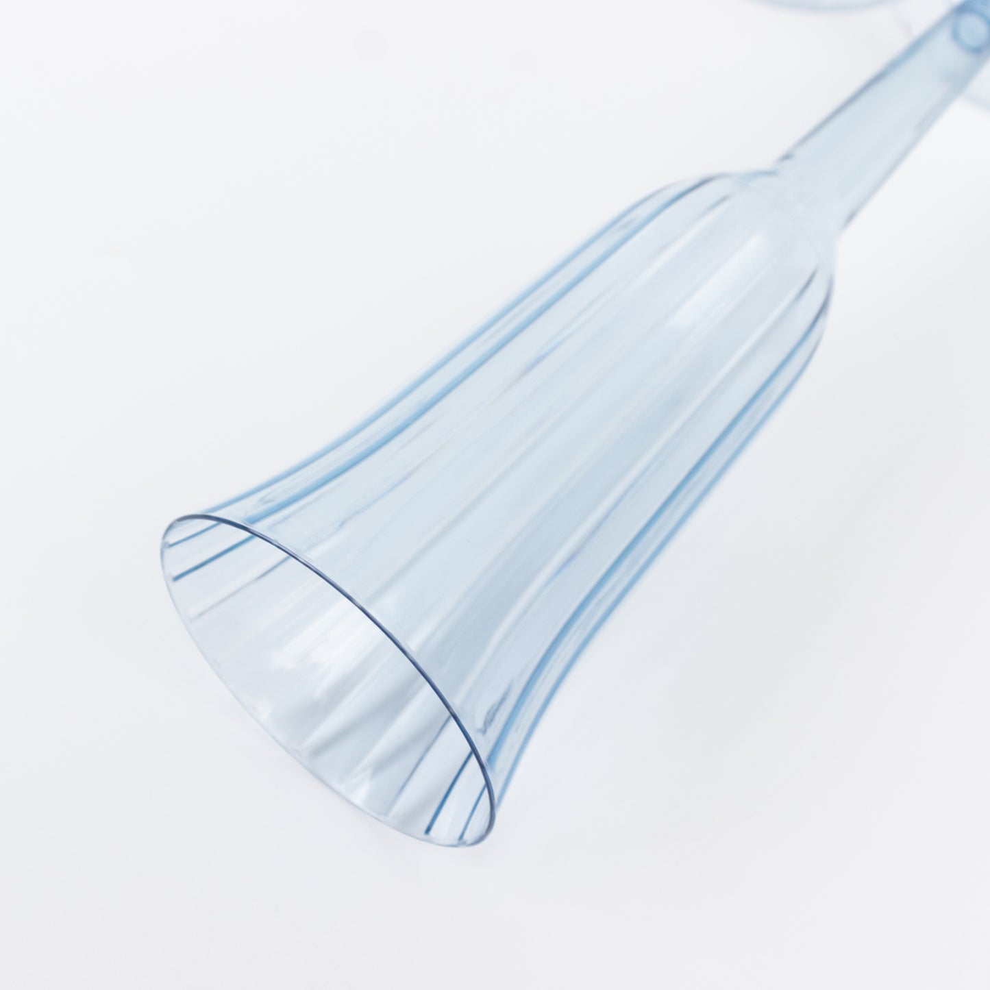 Transparent dusty blue flared plastic champagne flute on a white background.