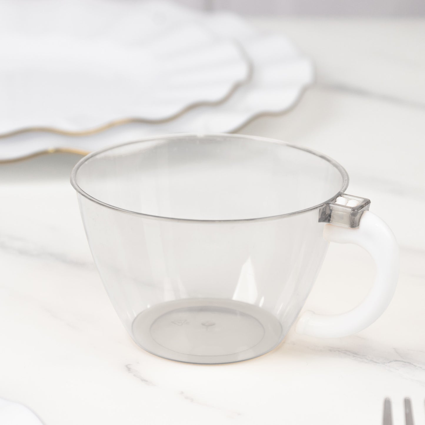 Clear disposable plastic coffee cup with handle for hot beverages.