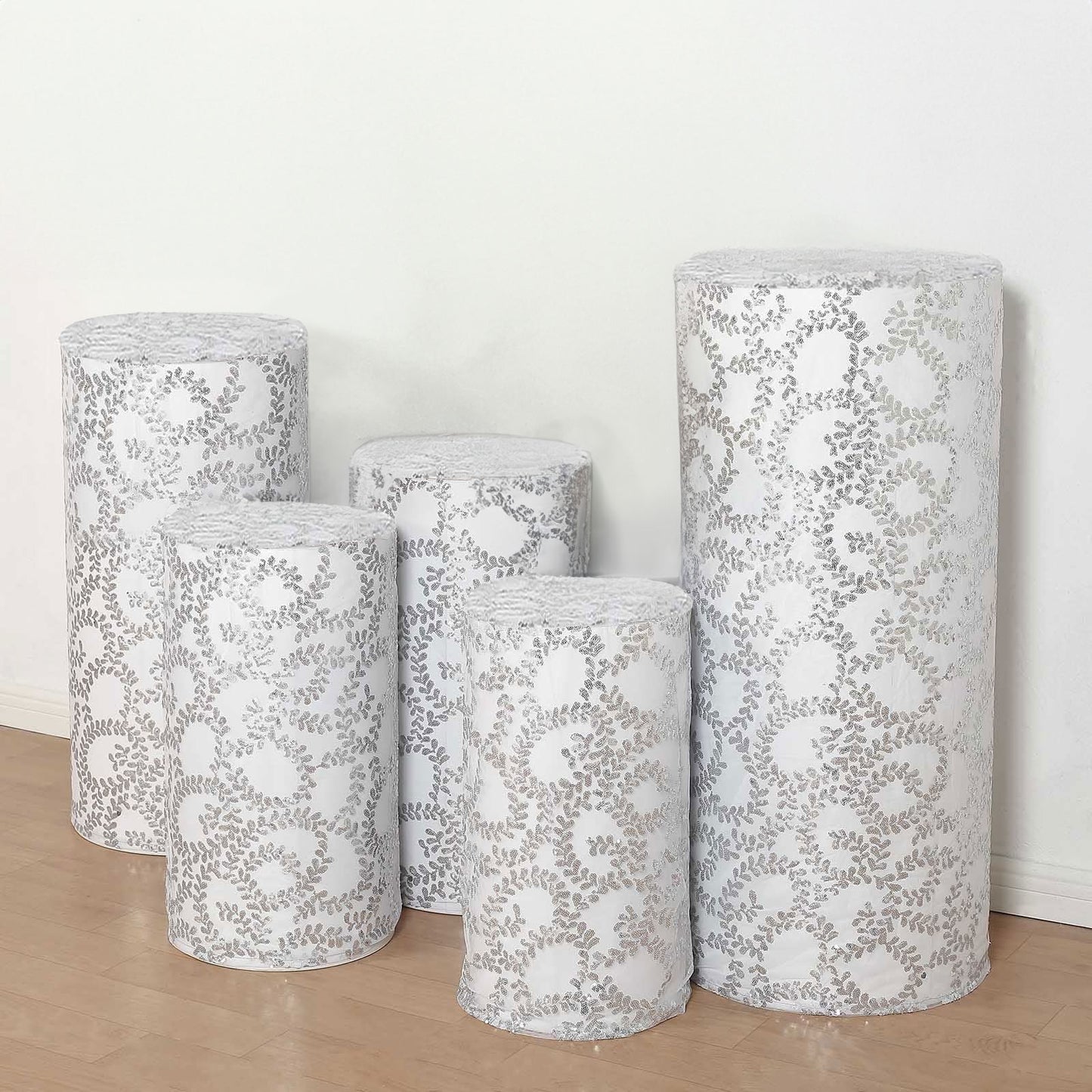 Silver sequin mesh pedestal stand covers with leaf vine embroidery.