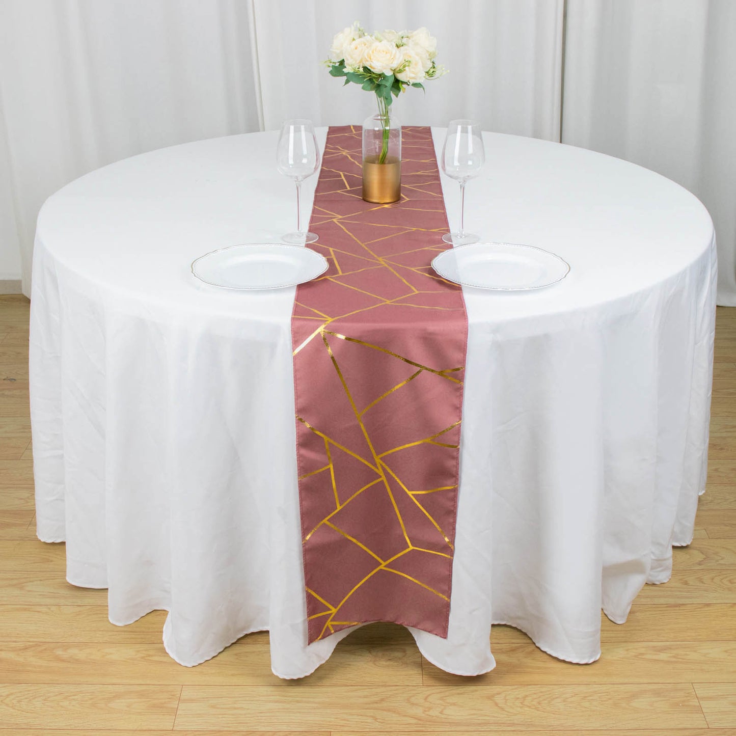 Cinnamon rose table runner with gold foil geometric pattern on a round table.