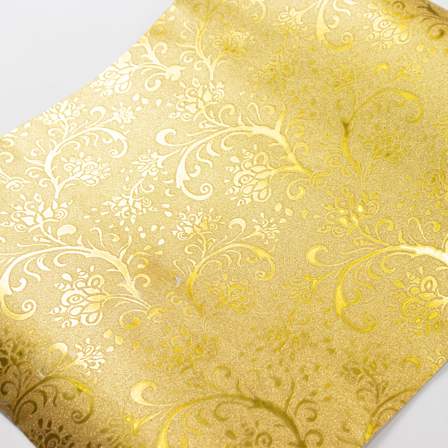 Gold glitter paper table runner with vintage floral vine pattern.