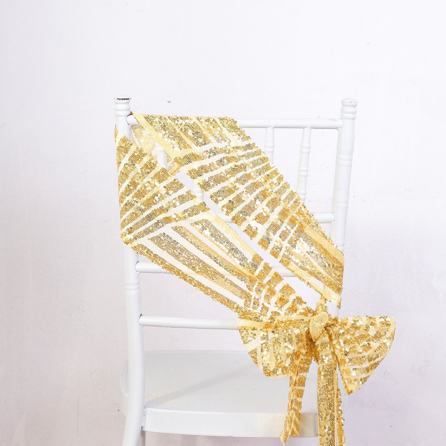 Gold geometric diamond glitz sequin chair sash on a white chair.