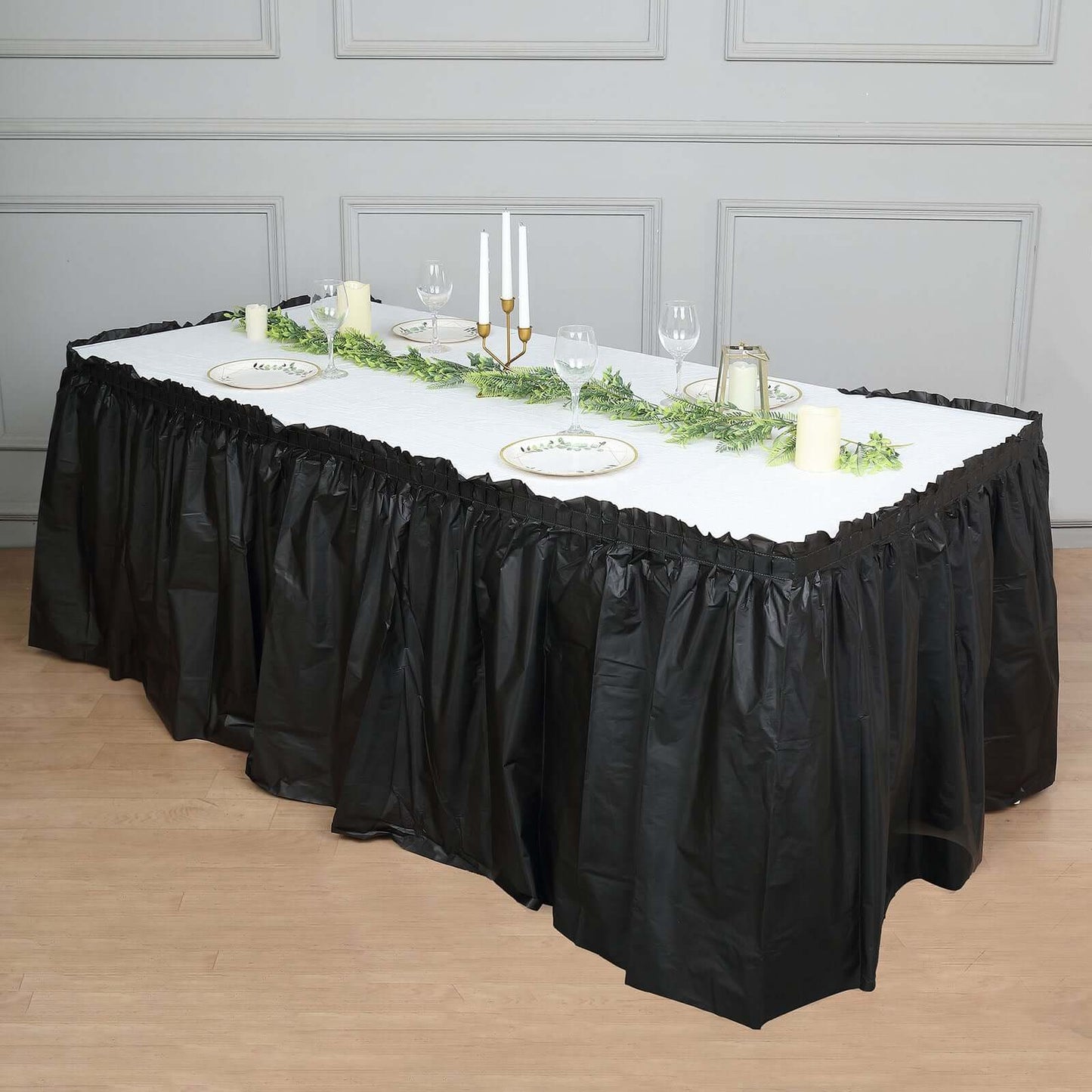 Black ruffled plastic table skirt for events, 14ft long.