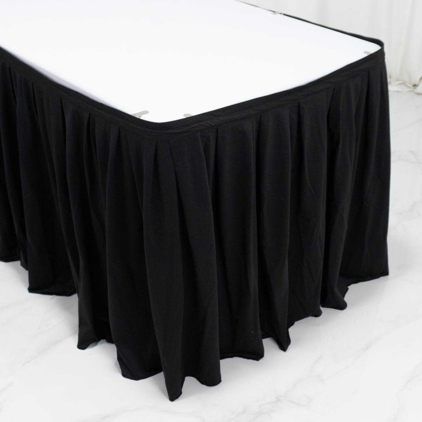 Black wrinkle-free event table skirt with shirred pleat design.