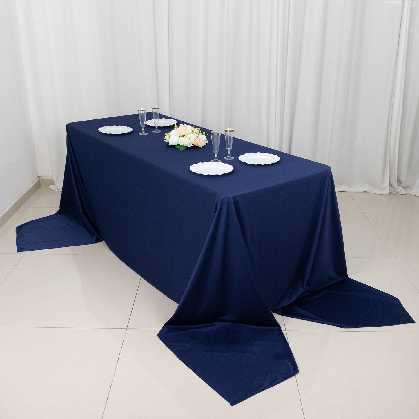90"x156" navy blue wrinkle-free rectangular tablecloth on a table.