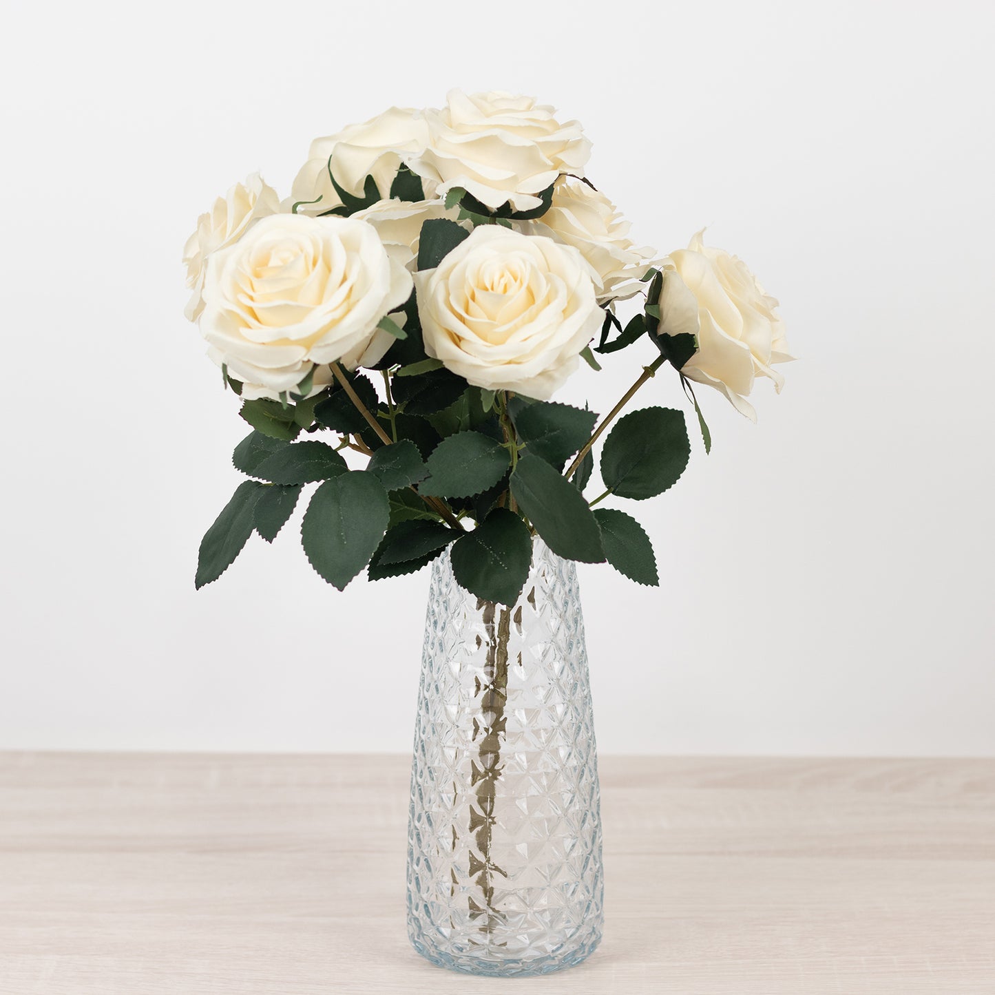 Clear diamond crystal cut vase with white roses.