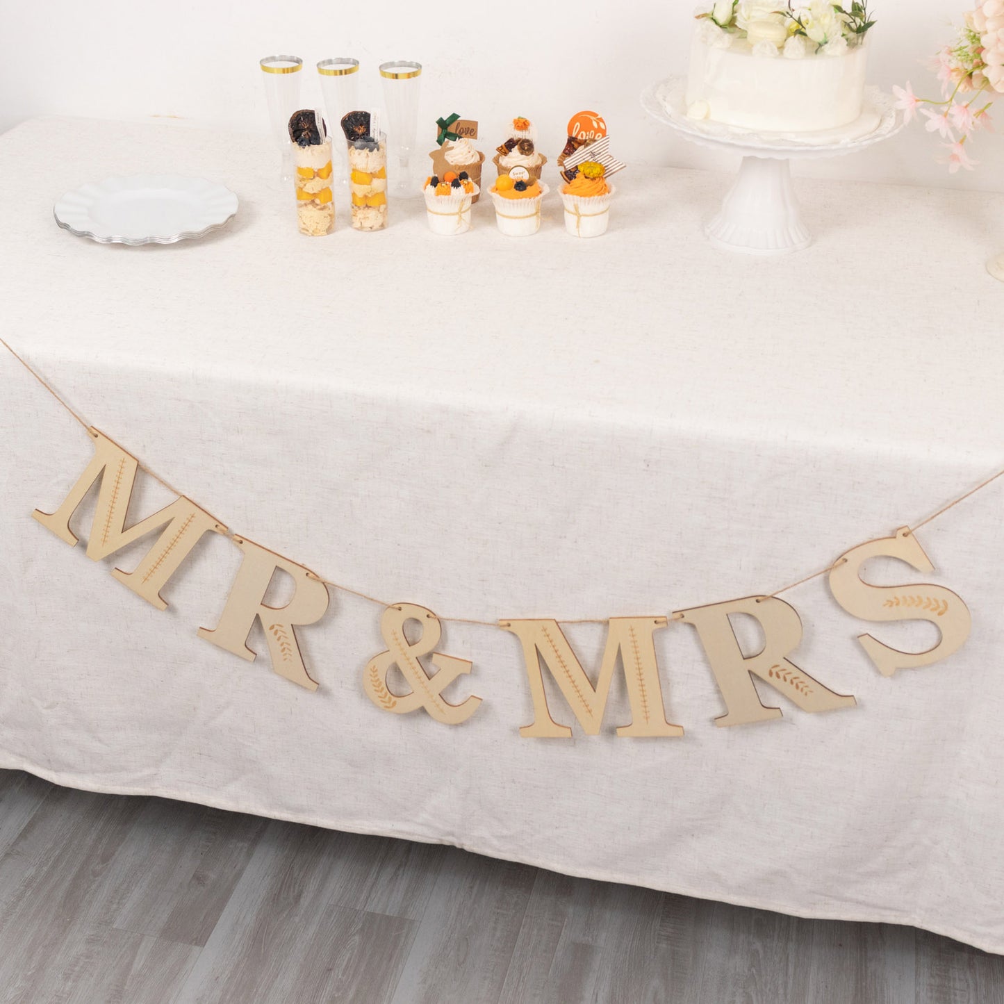 Natural wooden Mr & Mrs banner with botanical design, perfect for weddings.