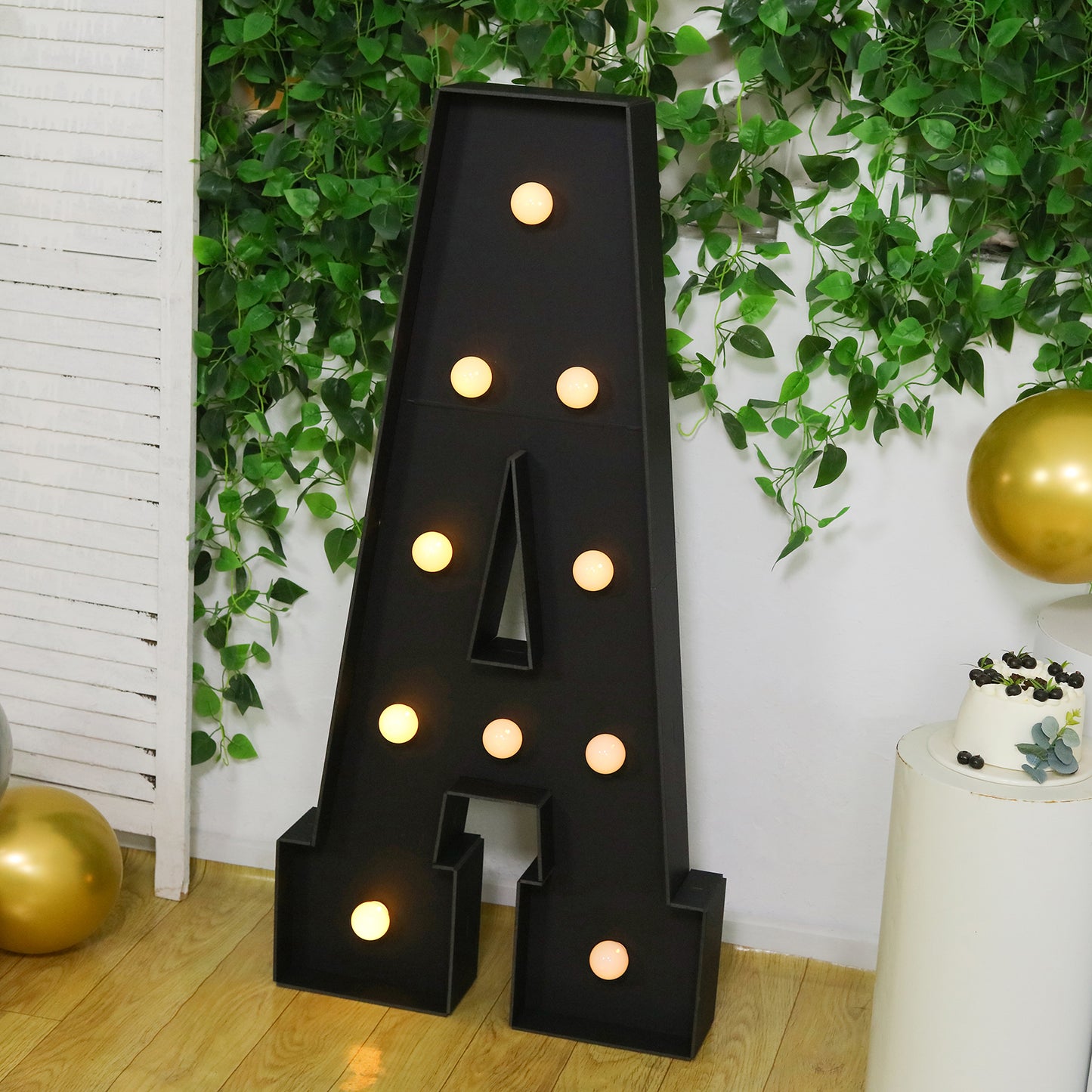 Black giant LED marquee letter "A" with warm white lights.