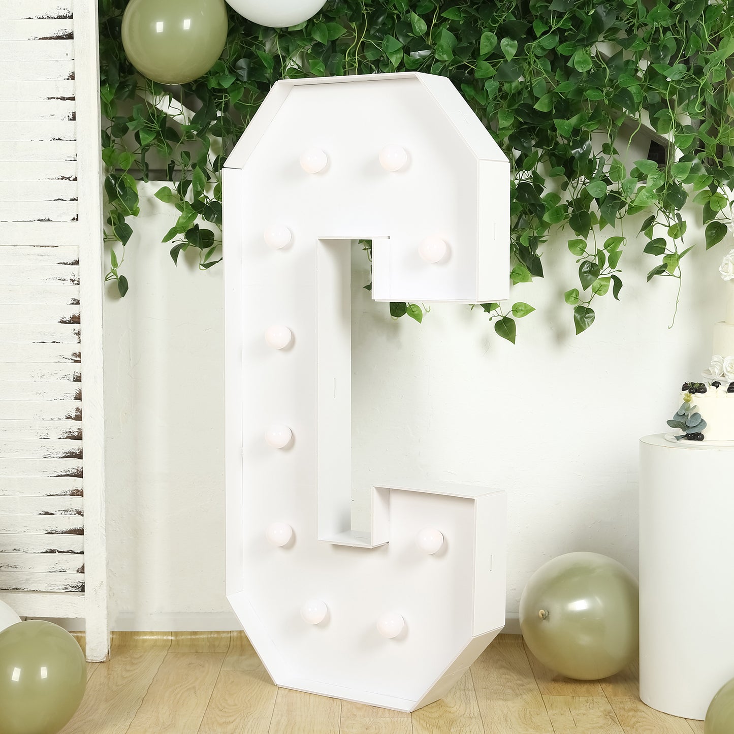 White LED marquee letter "C" with warm white bulbs in a festive setting.