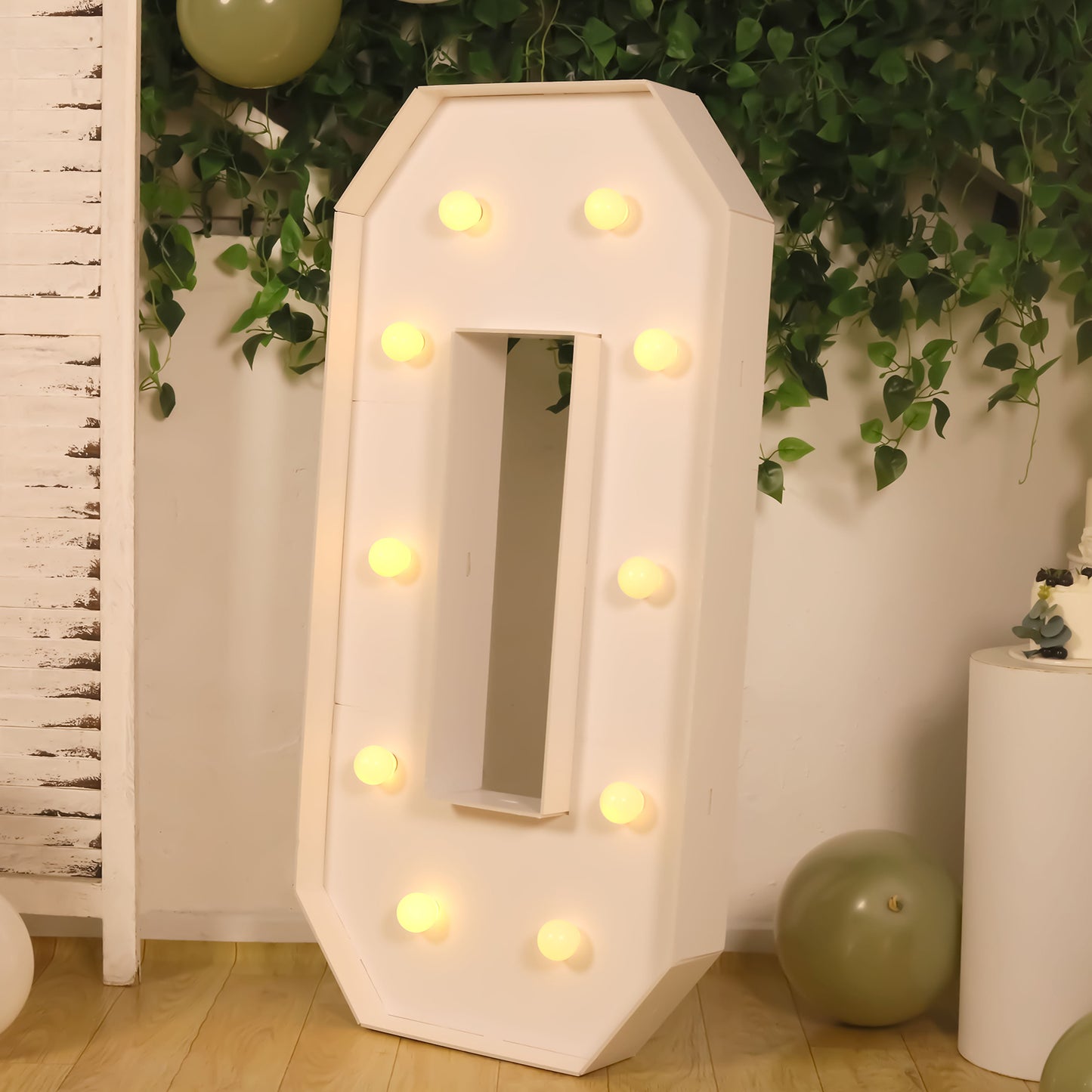 White LED marquee letter "O" with warm white lights on a decorative background.