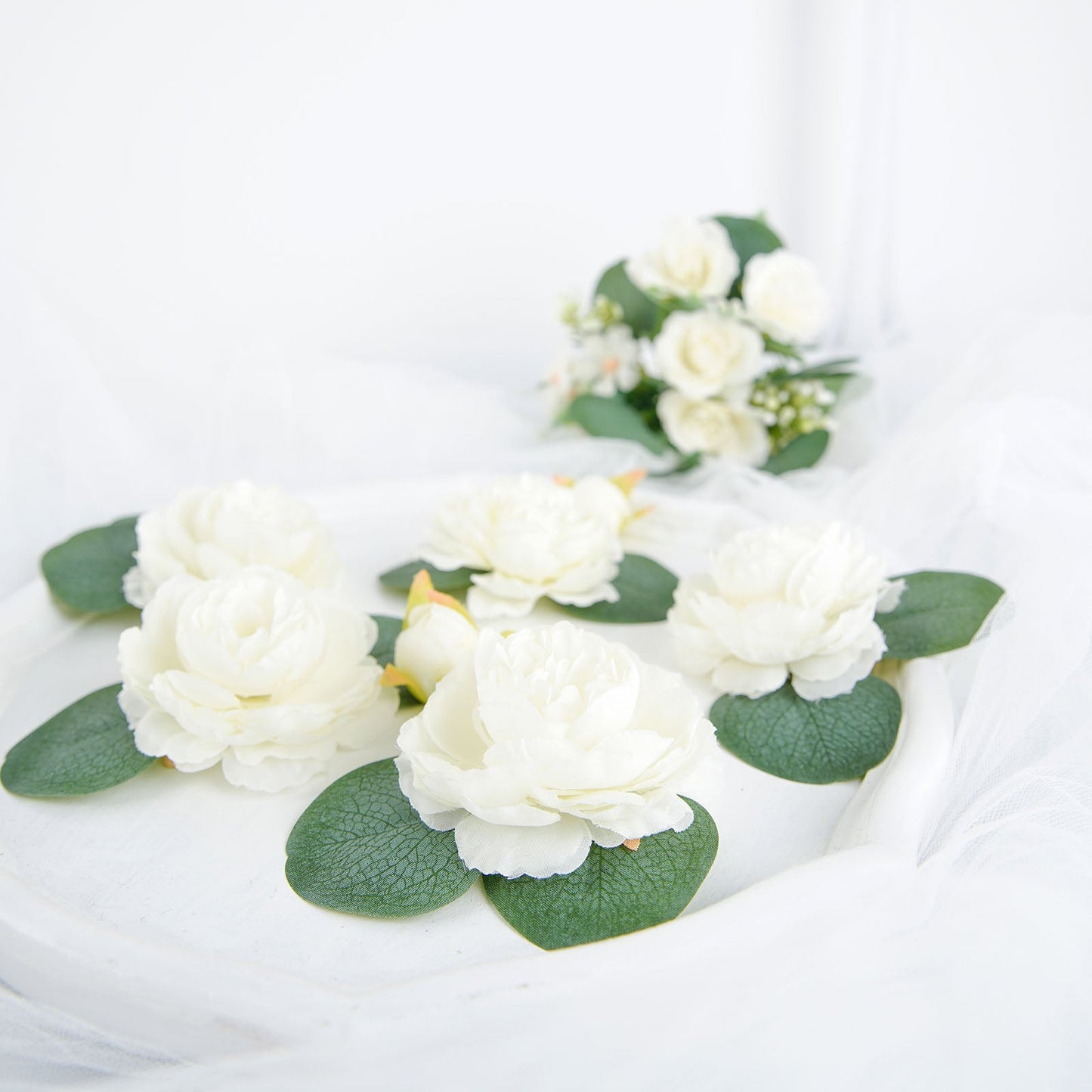 Frosted green eucalyptus leaves on a white surface, ideal for decoration.