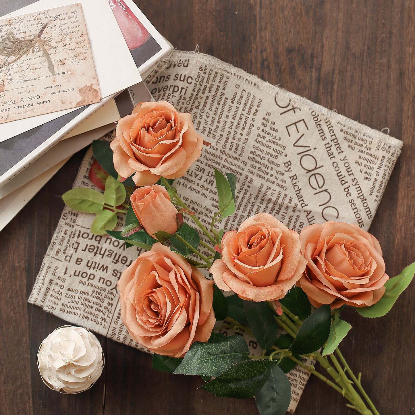 Dusty rose artificial silk rose flower bouquet on a rustic background.