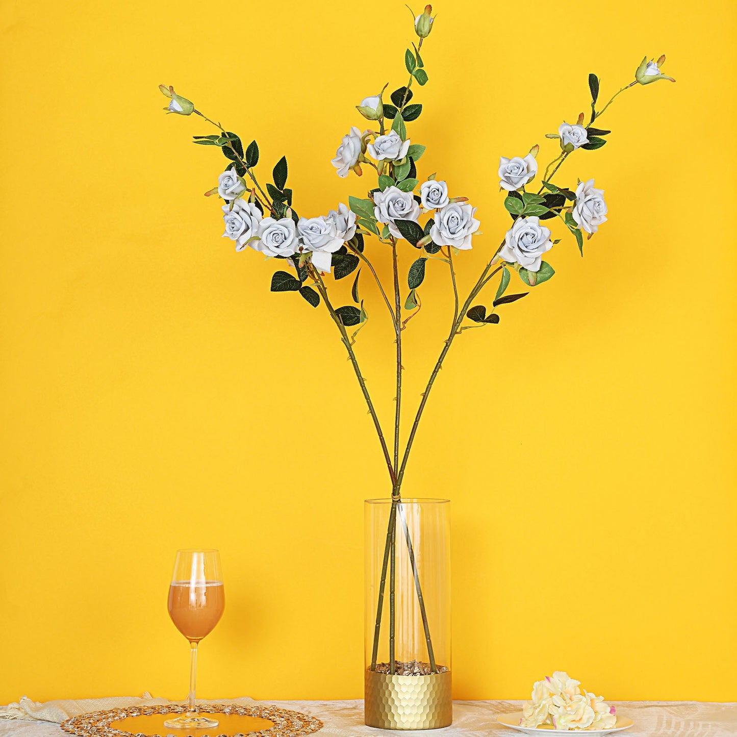 Silver artificial silk rose flower bouquet in a tall vase.