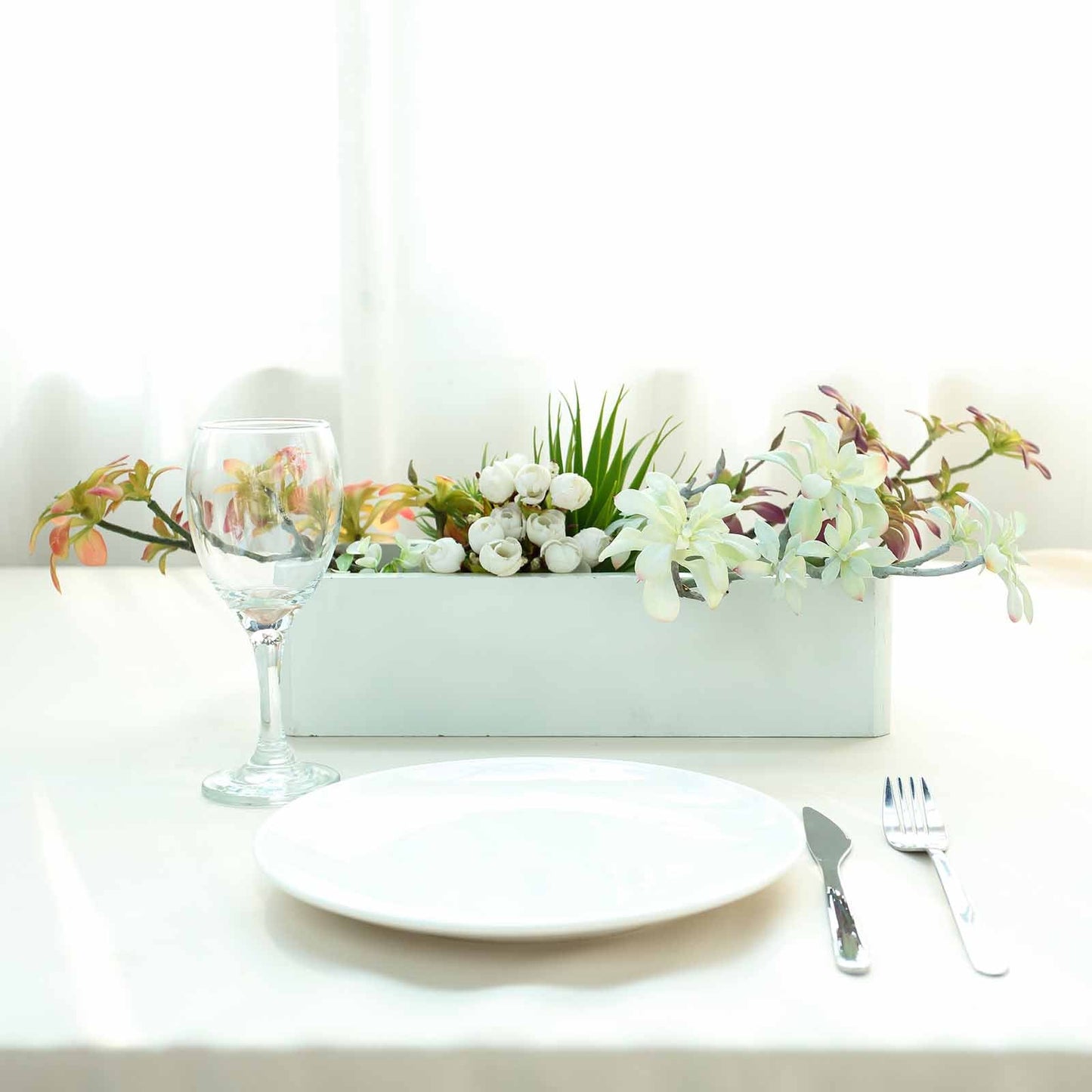Assorted artificial aeonium spray succulent air plants in a white planter.