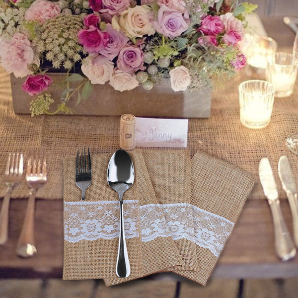 Natural burlap and lace silverware holder pouch on a rustic table setting.