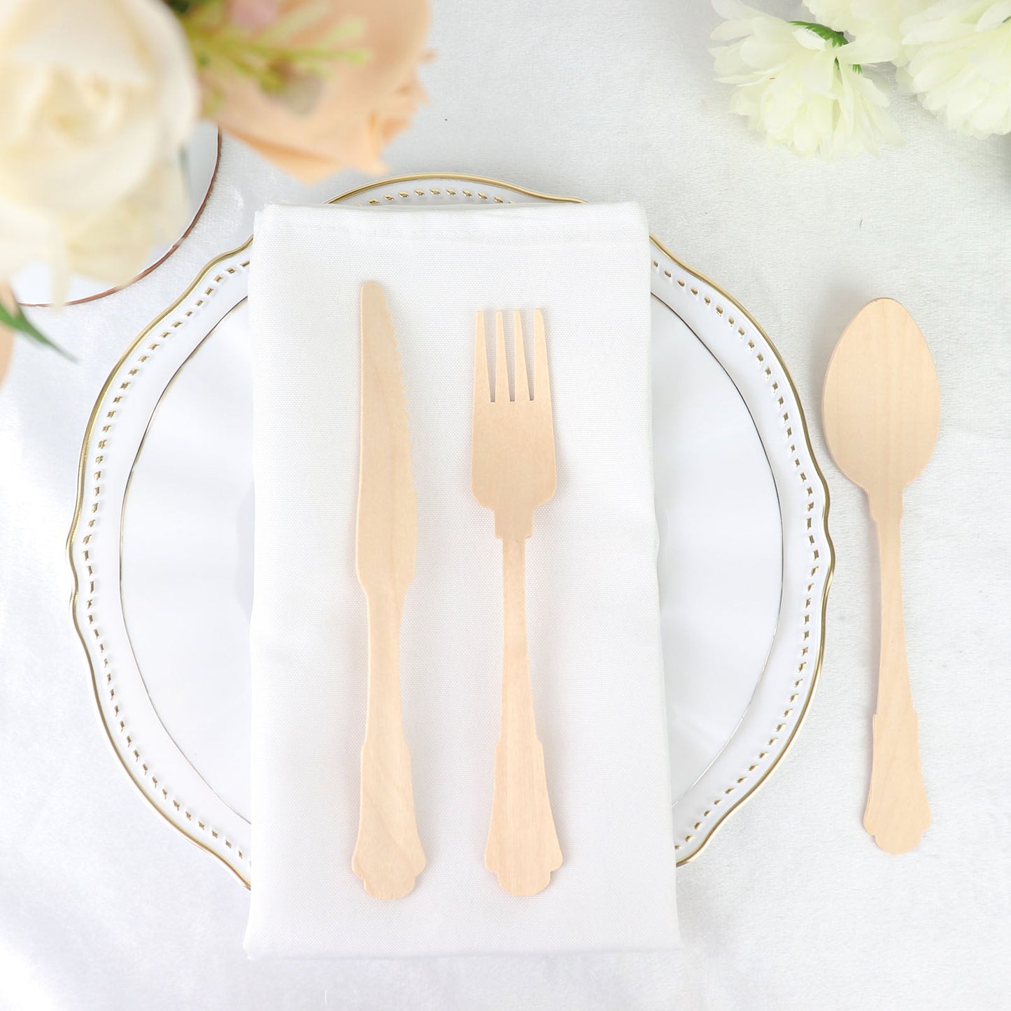 Vintage Baroque design disposable wooden utensil set on a white plate.