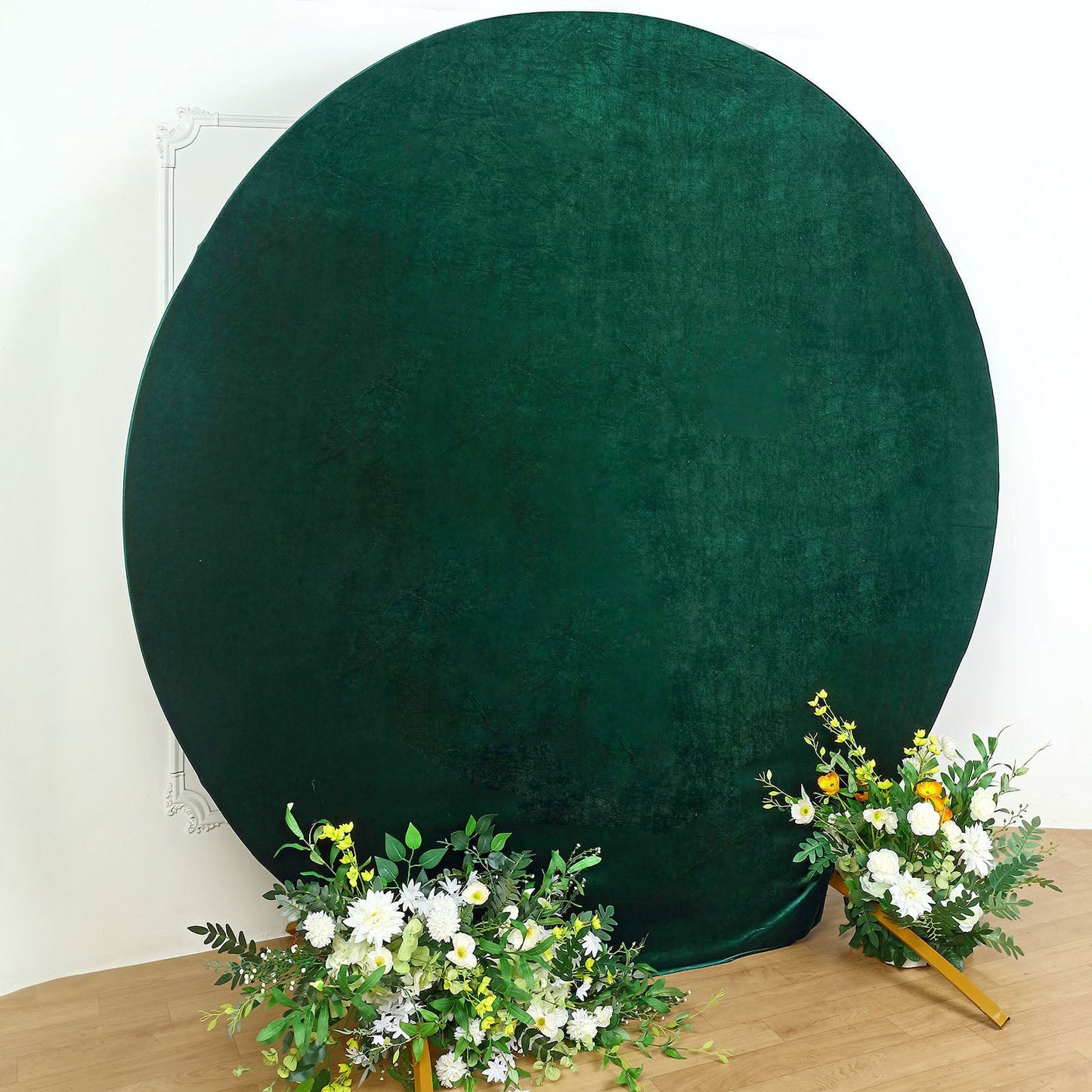 Emerald green velvet round wedding arch cover with floral arrangements.