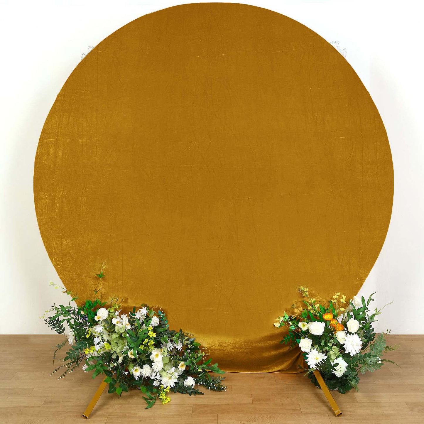 Metallic gold velvet round wedding arch cover with floral arrangements.