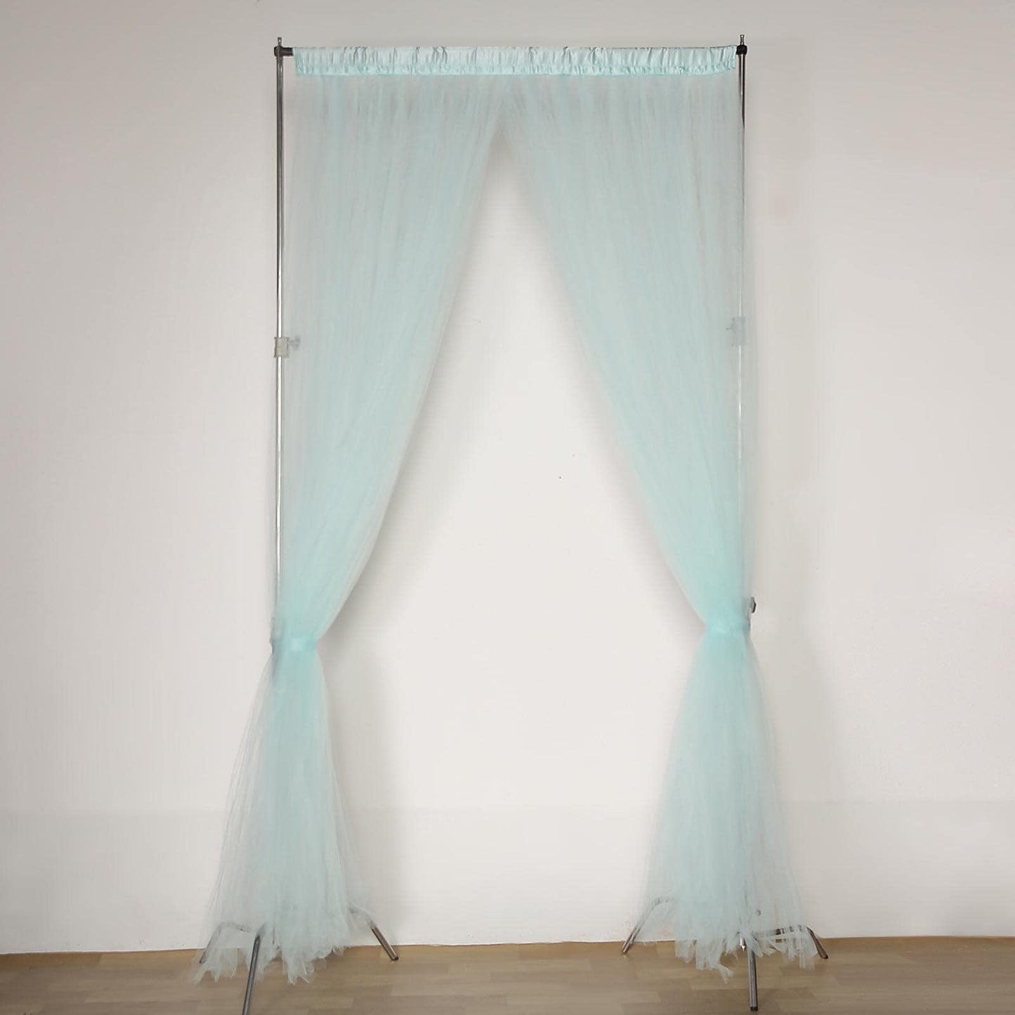 Light blue sheer tulle event curtain drapes with satin header.