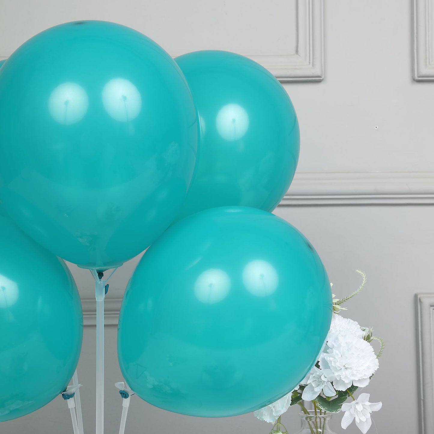Matte pastel peacock teal balloons arranged for a party decoration.
