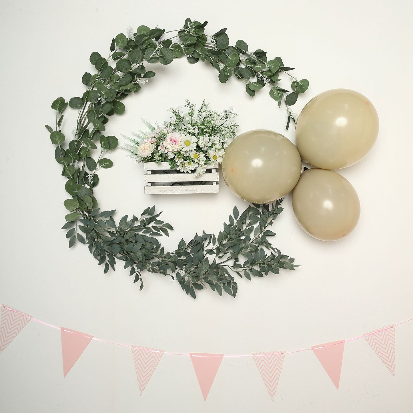 Matte nude double stuffed latex balloons arranged with greenery and flowers.