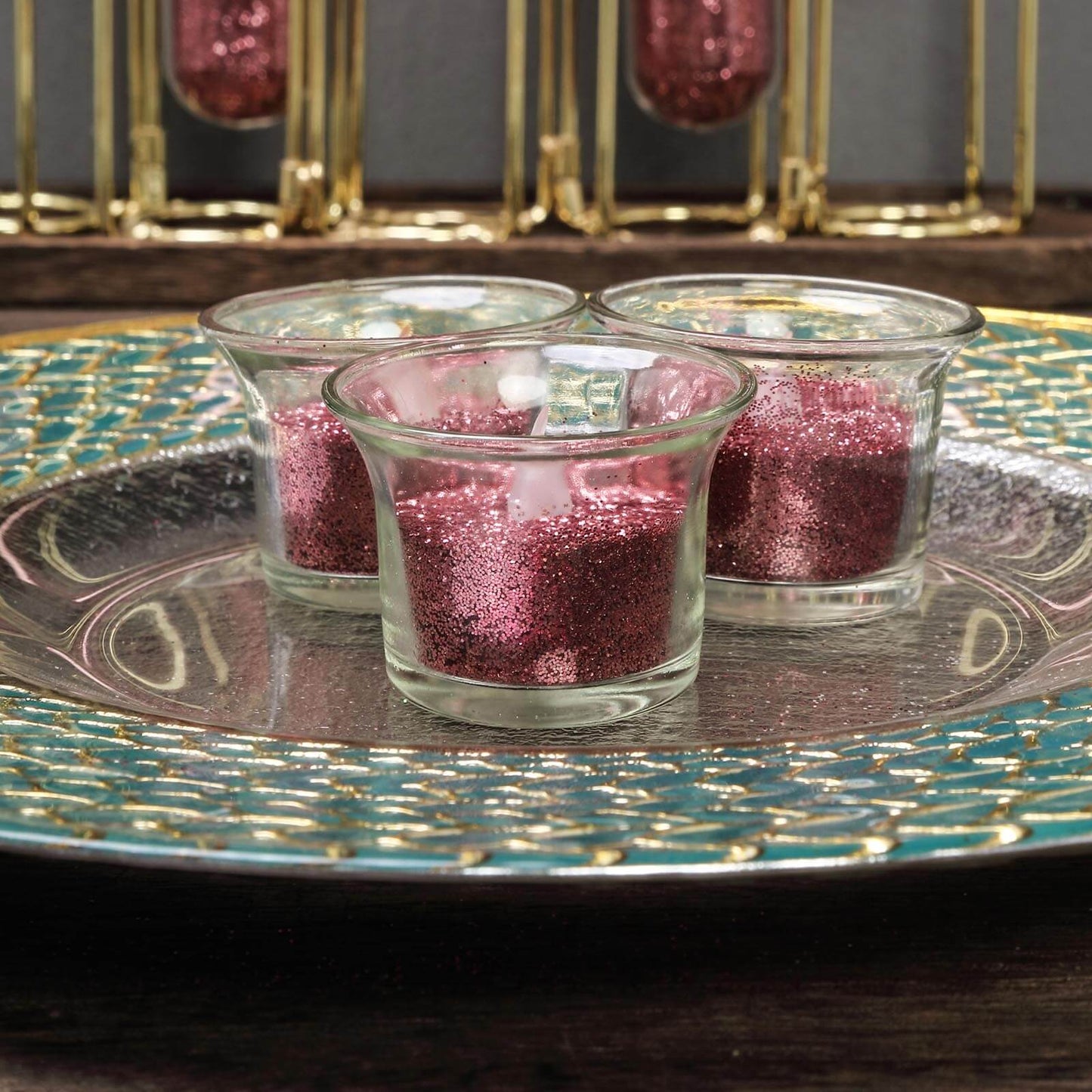 Rose gold extra fine glitter in glass containers on a decorative plate.