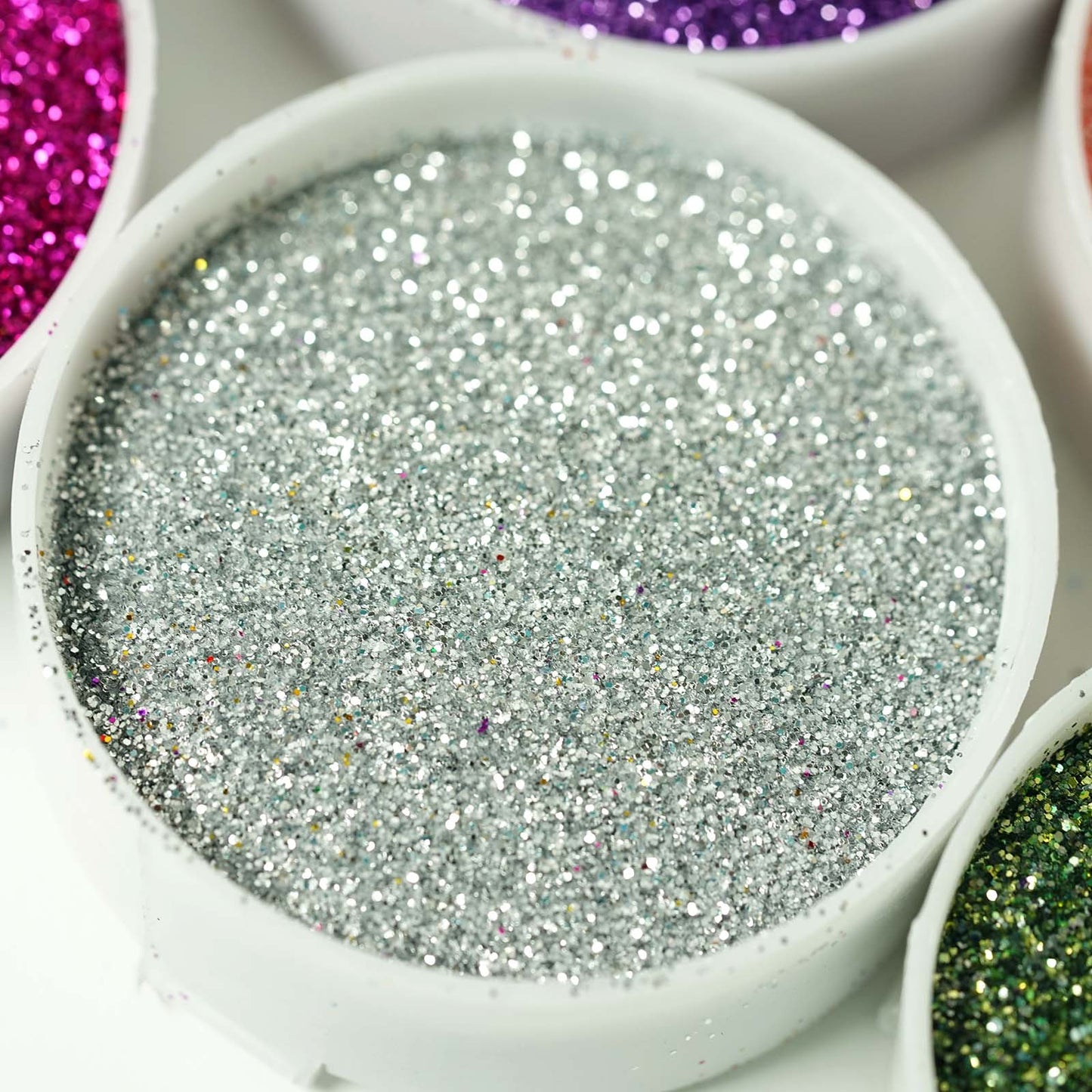 Extra fine silver glitter in a round container for DIY arts and crafts.