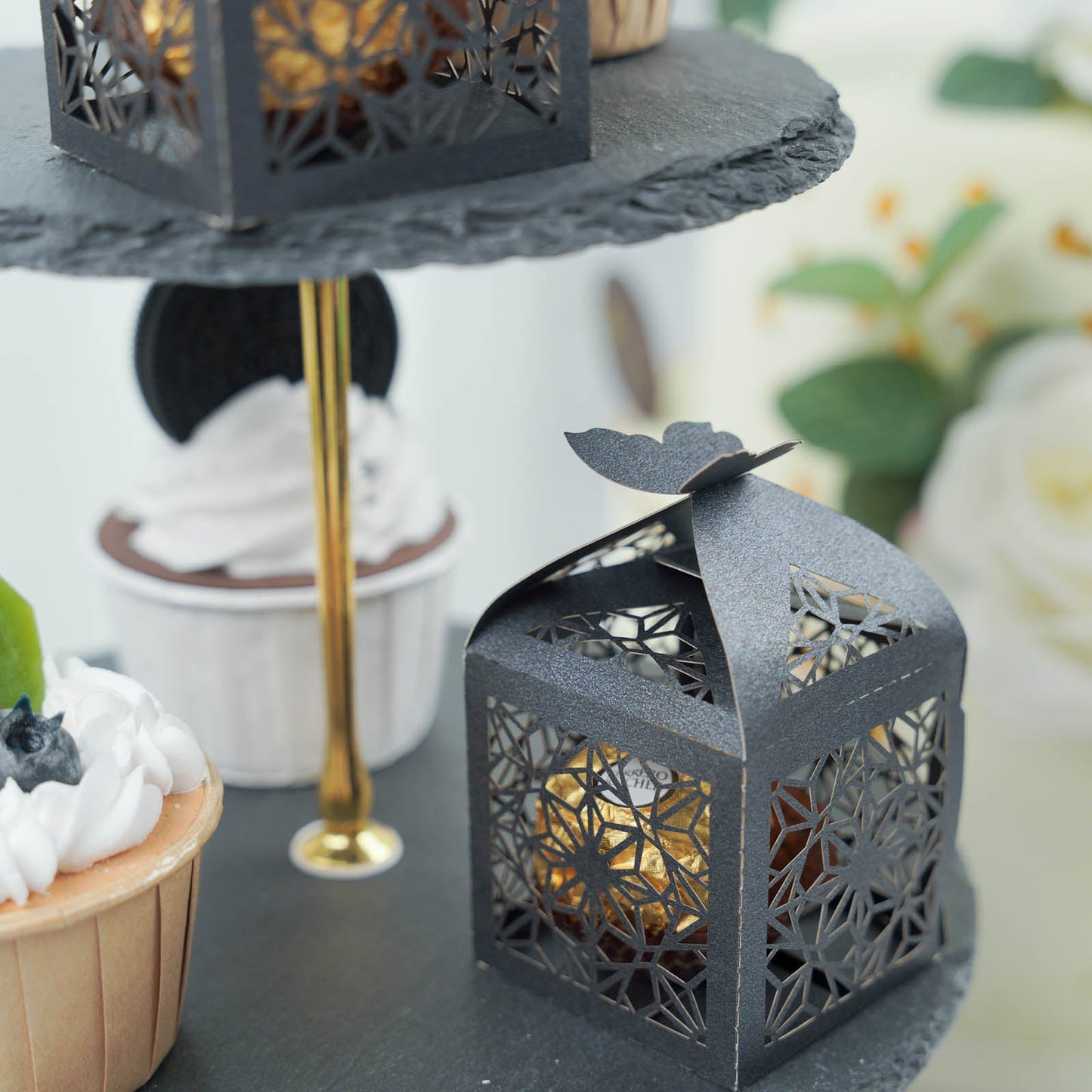 Black butterfly top laser cut lace favor candy gift boxes on a display.