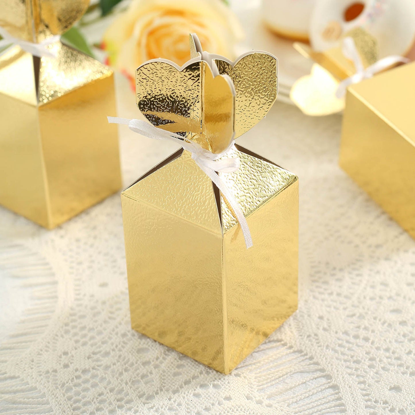 Gold floral satin ribbon gift boxes for party favors.