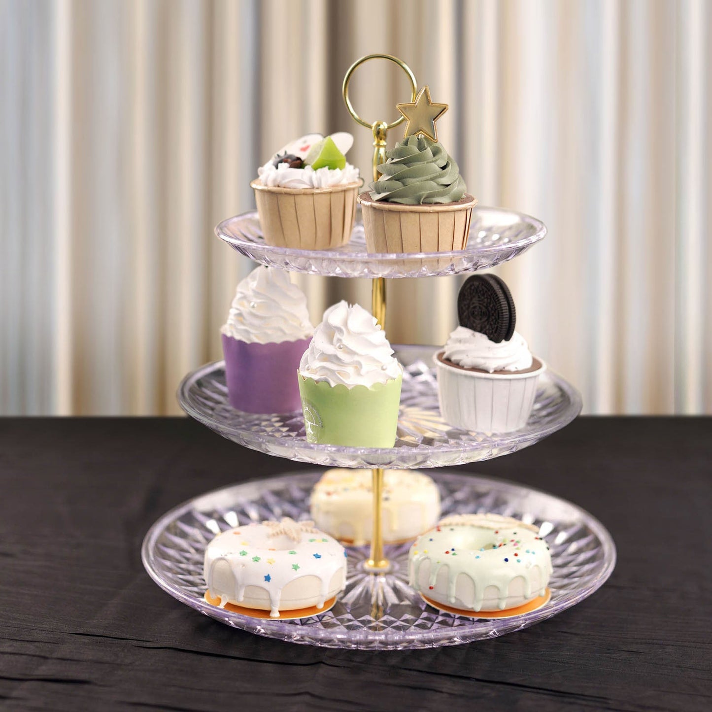 Clear acrylic cupcake stand displaying colorful desserts.