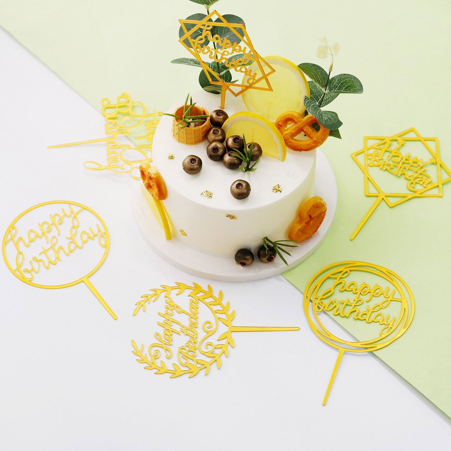 Gold acrylic birthday cake toppers set on a decorated cake.