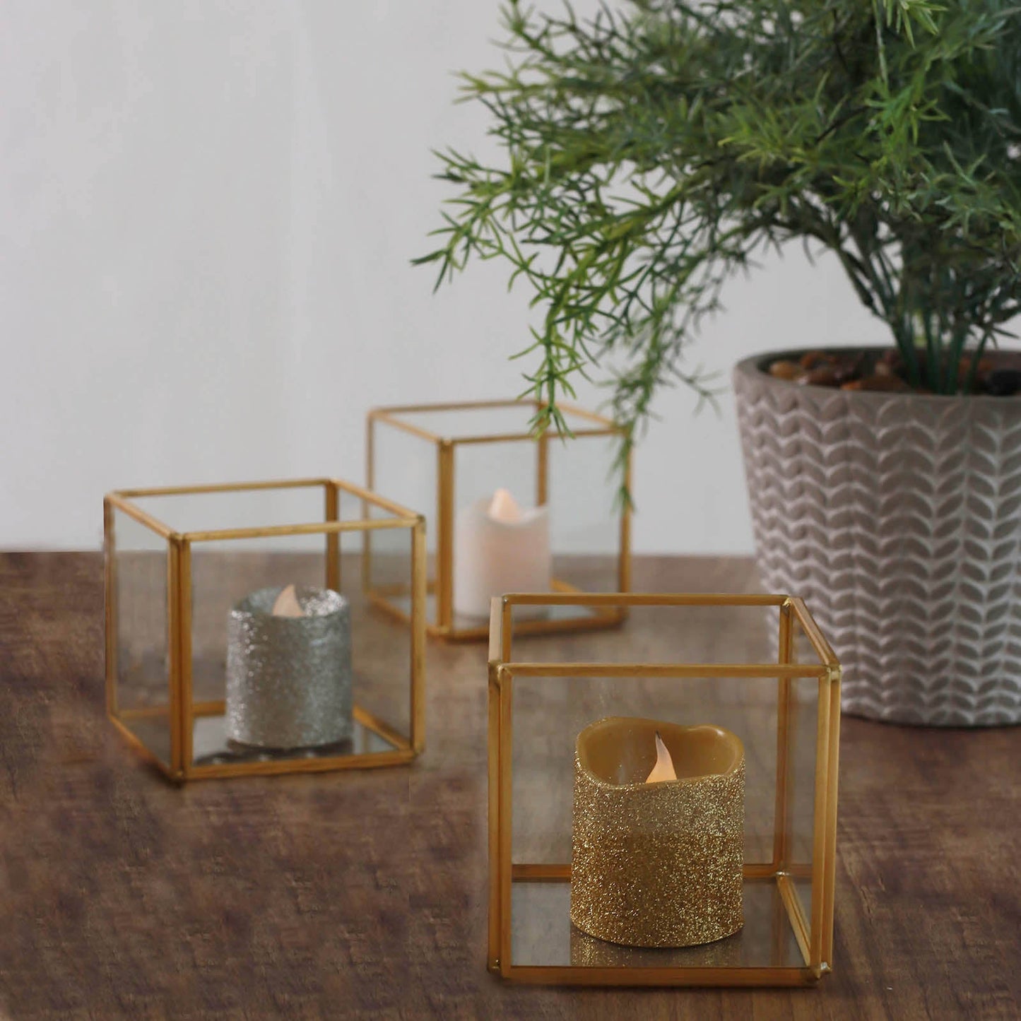Clear glass square tealight candle holders with gold metal frames.