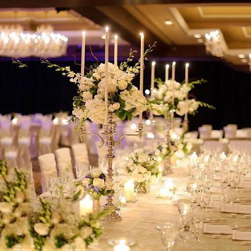Gold metal candelabra with floral arrangements and candles for elegant decor.