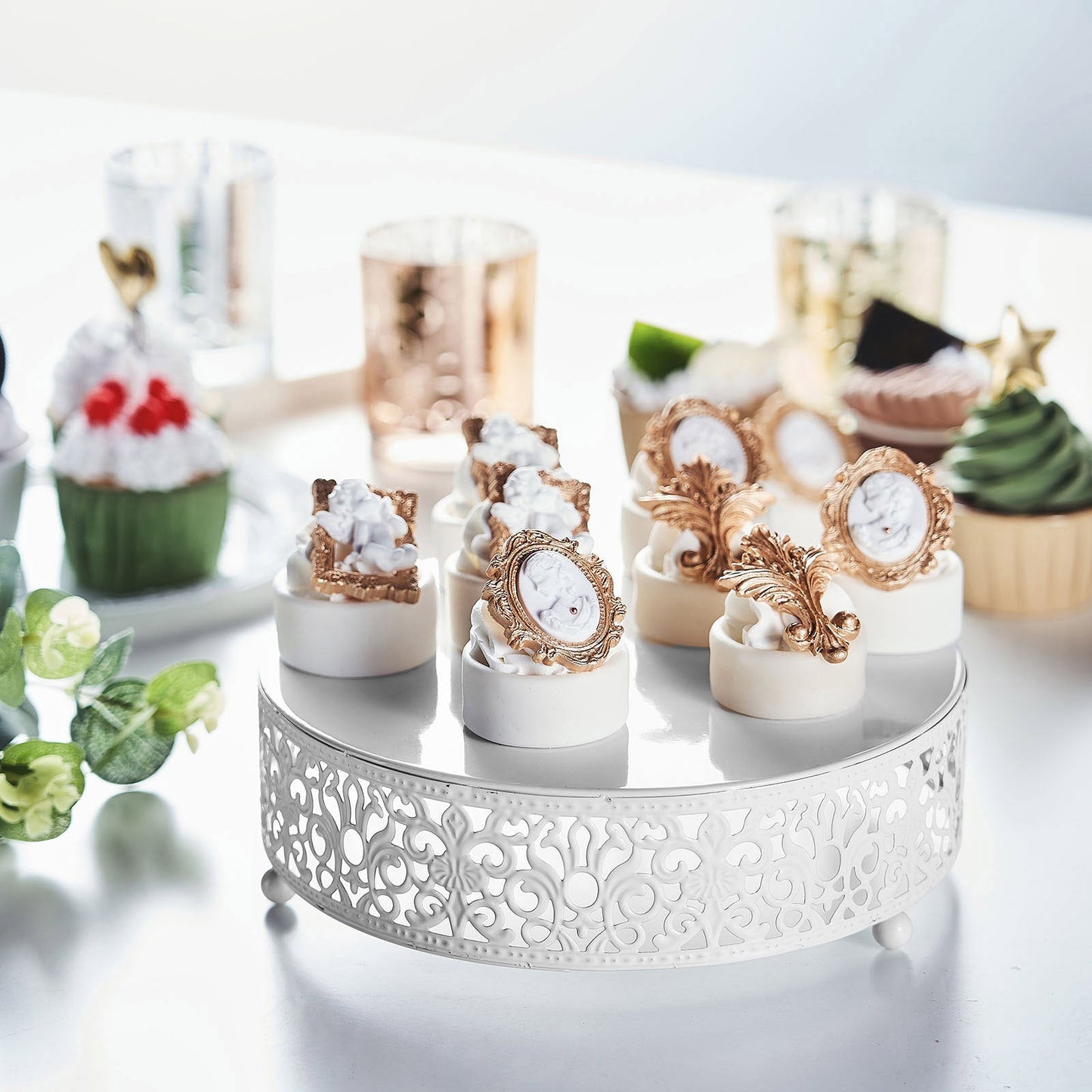 White metal wedding cake stand with elegant cupcake display.