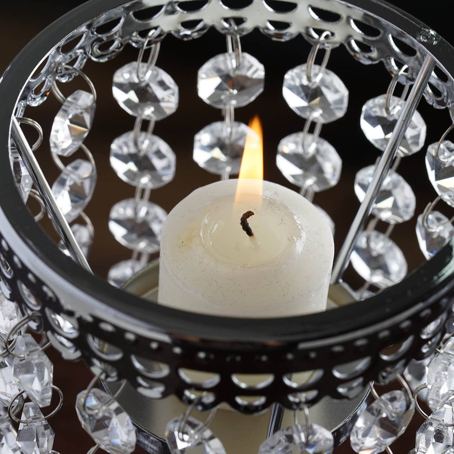 Silver crystal beaded chandelier votive candle holder with lit pillar candle.