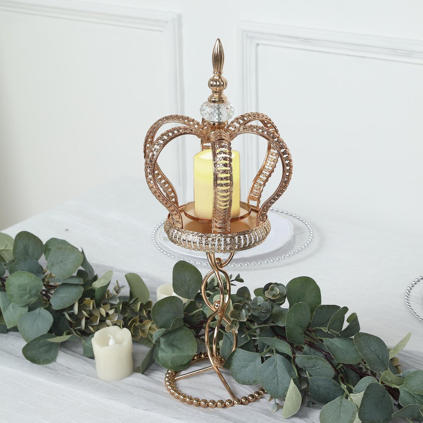 Gold crown spiral pillar candle holder with jeweled accents.