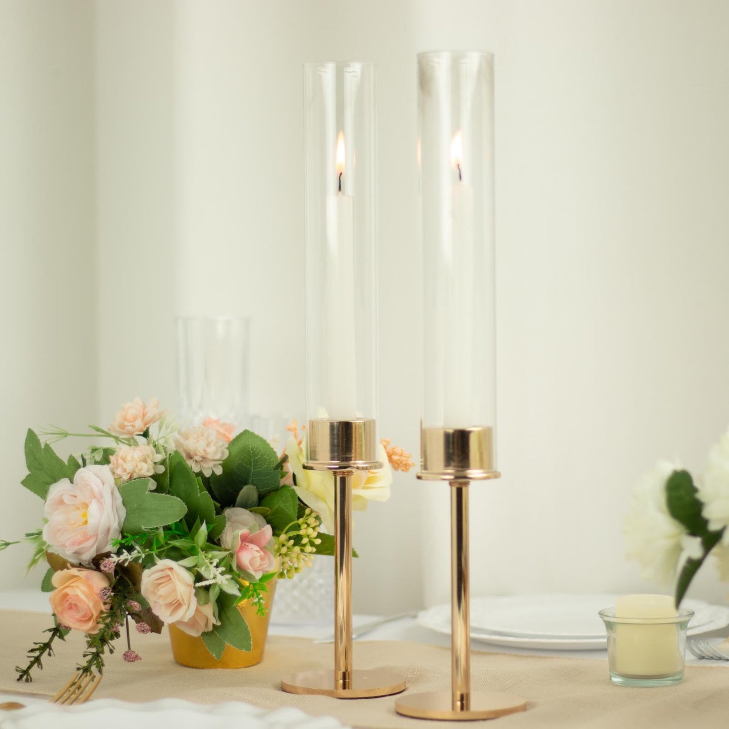 Gold metal candle holders with clear glass shades, perfect for elegant decor.