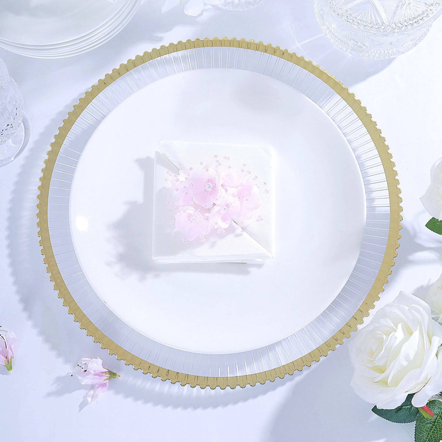 Clear wavy gold rim acrylic charger plate with pink floral napkin.