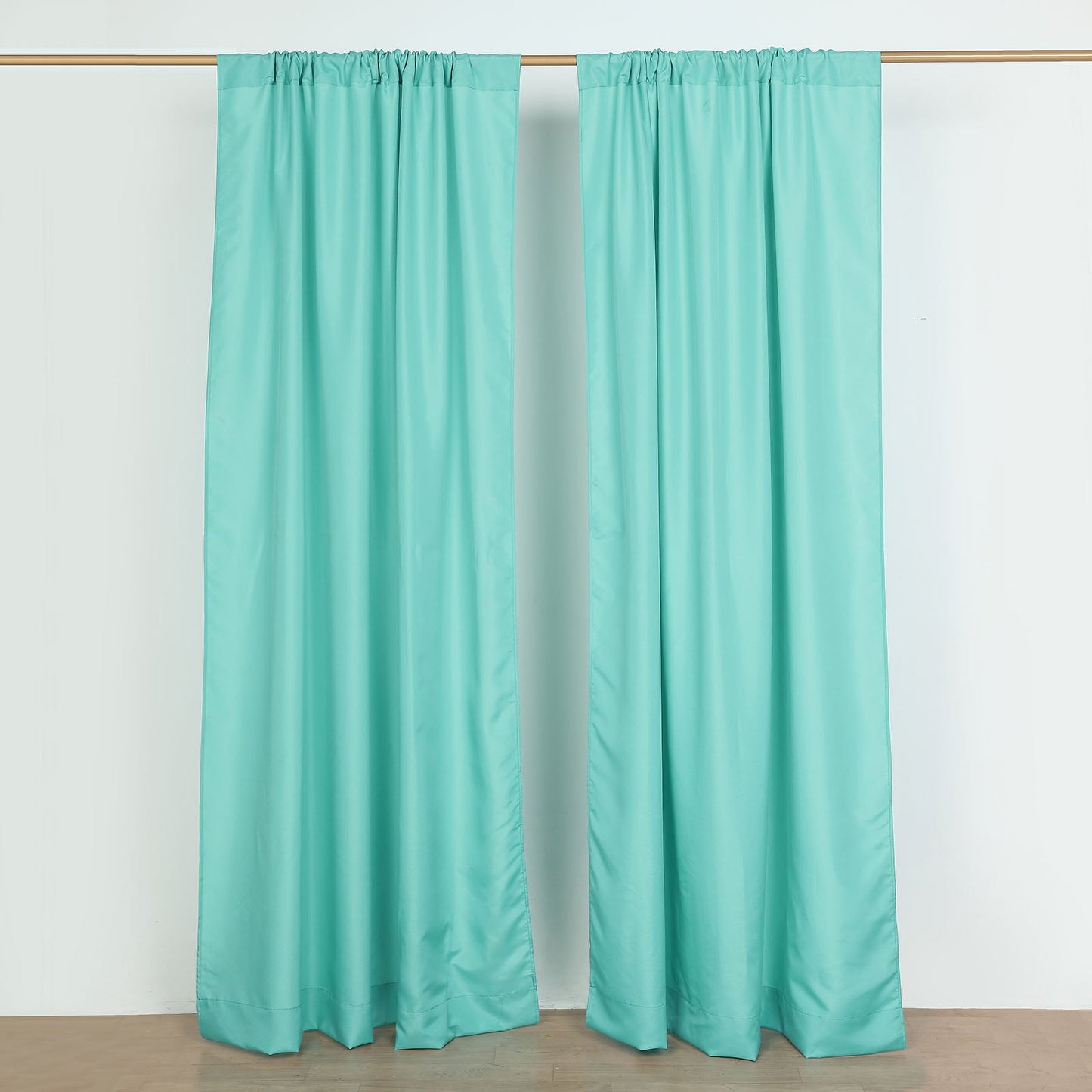 Turquoise polyester backdrop drape curtains with rod pockets.