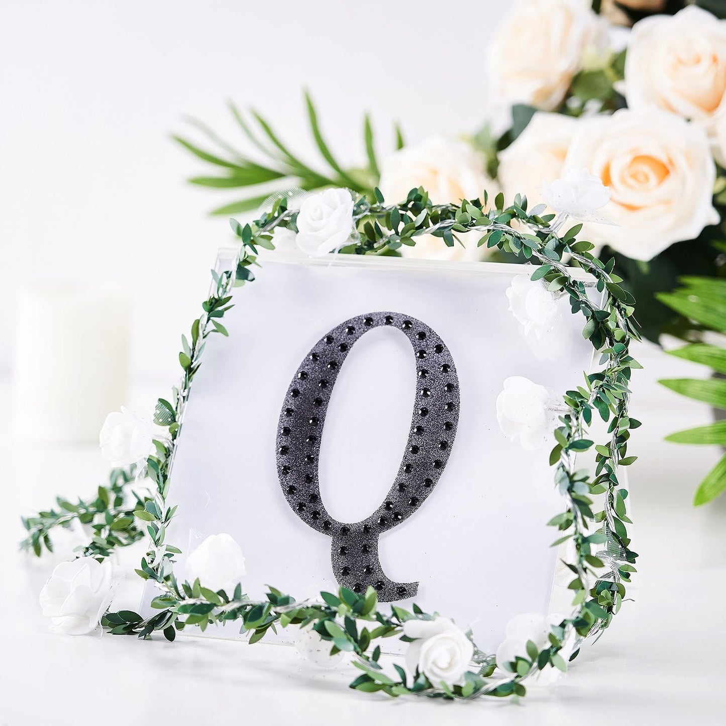 Black decorative rhinestone letter Q with floral accents.