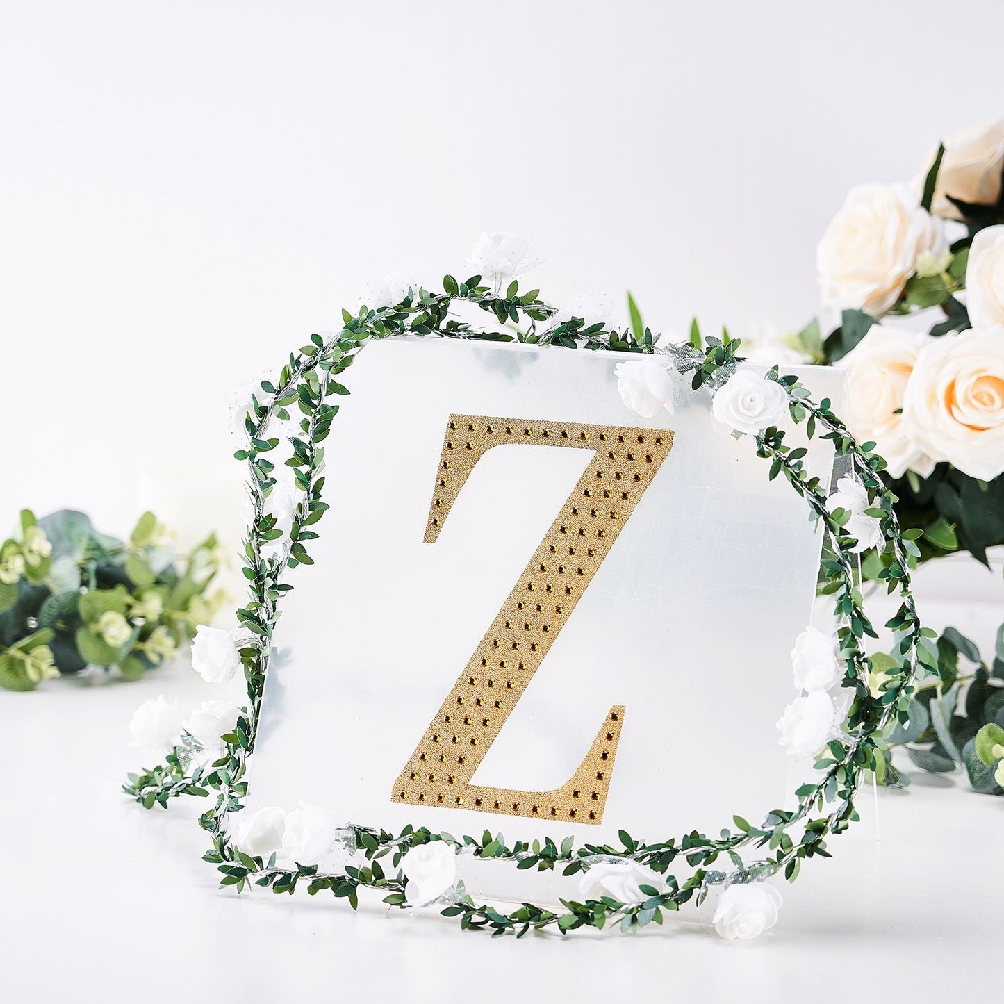 Gold decorative rhinestone letter "Z" surrounded by floral accents.