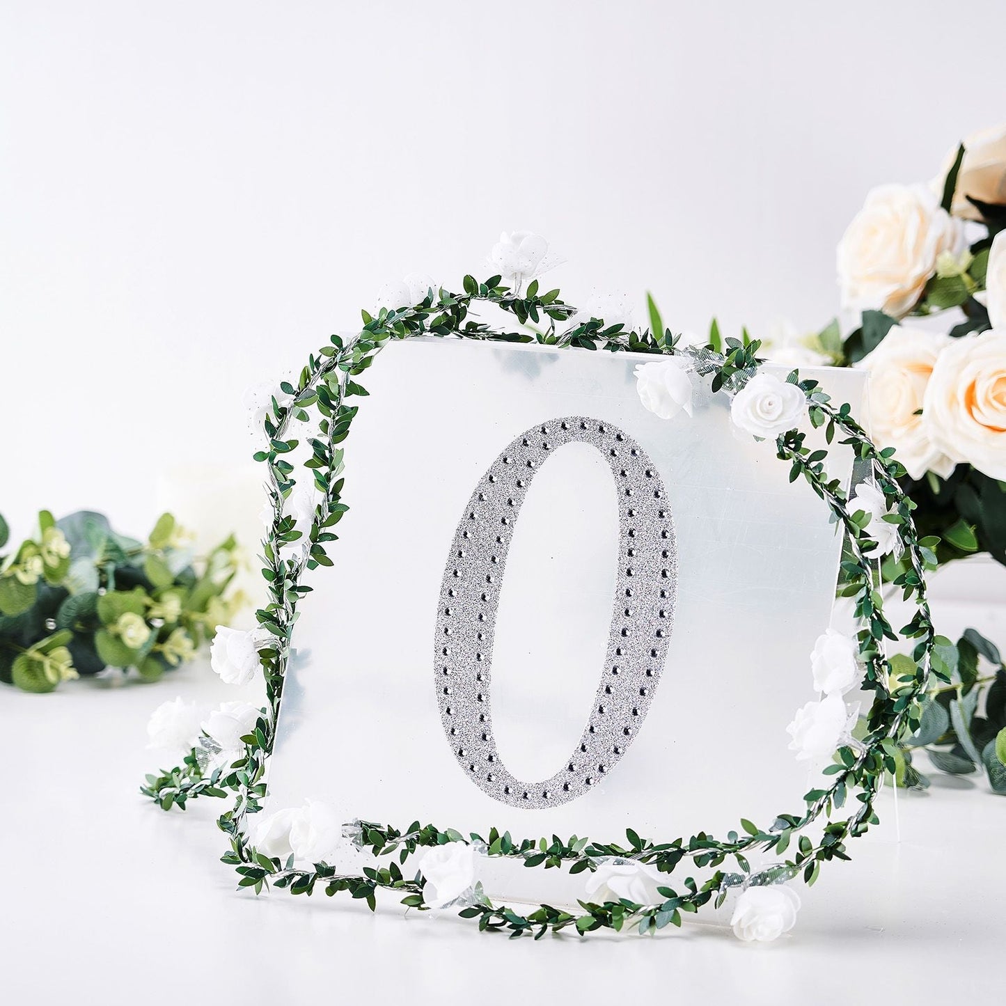 Silver decorative rhinestone letter "O" with floral accents.