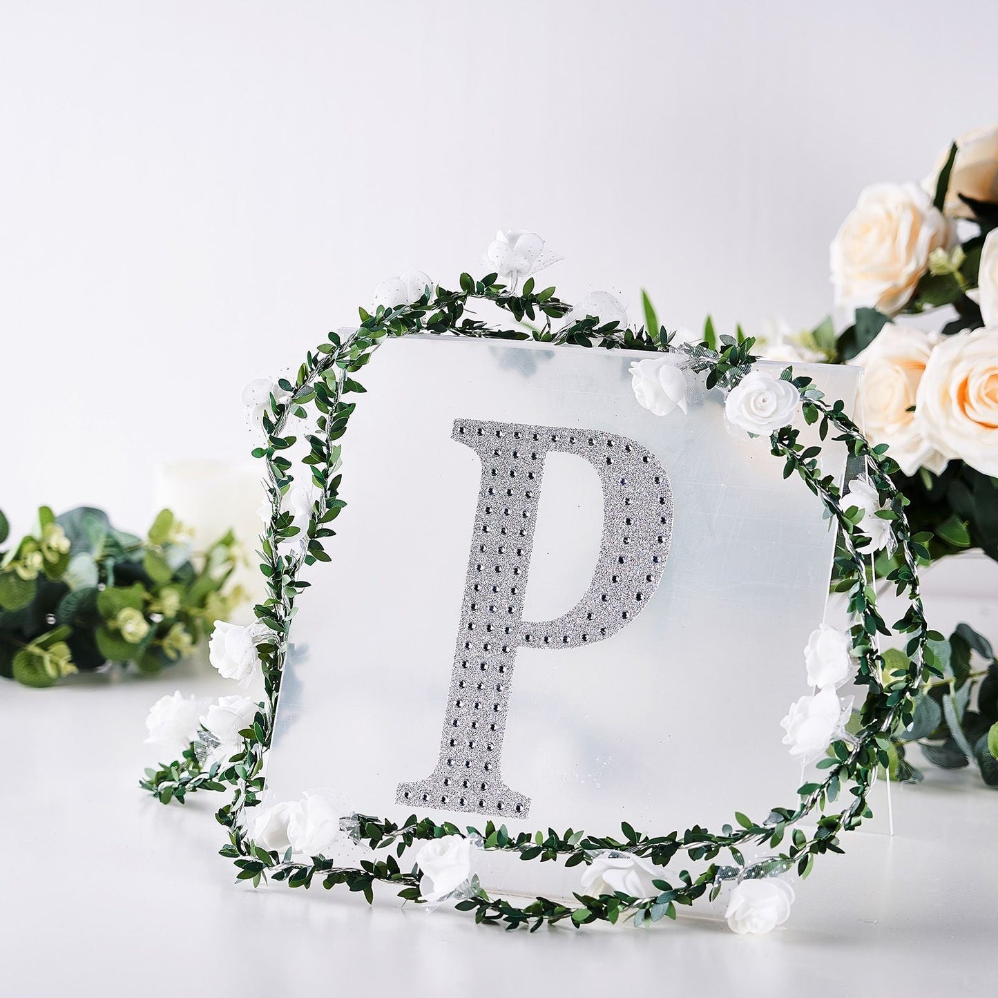 Silver decorative rhinestone letter "P" with floral accents.